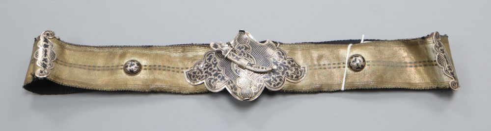 An Islamic silver and niello mounted brocade belt